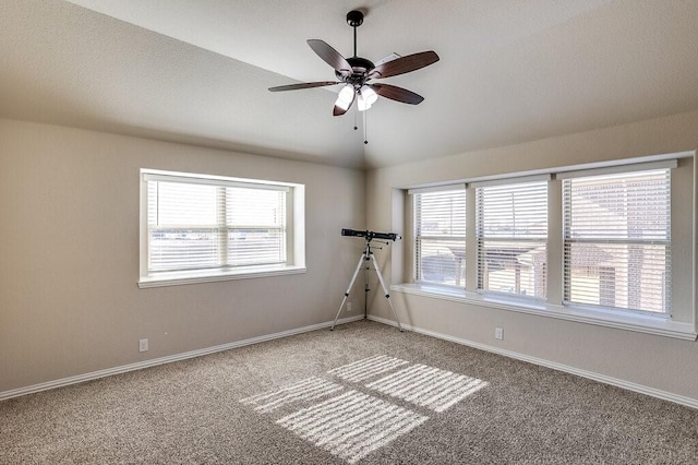 carpeted spare room with ceiling fan and lofted ceiling