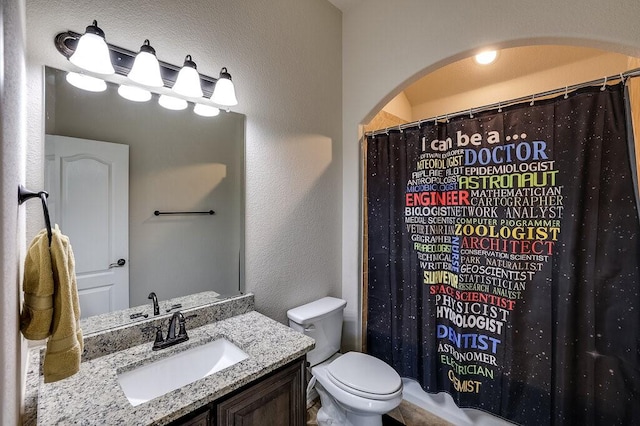 bathroom featuring a shower with curtain, vanity, and toilet