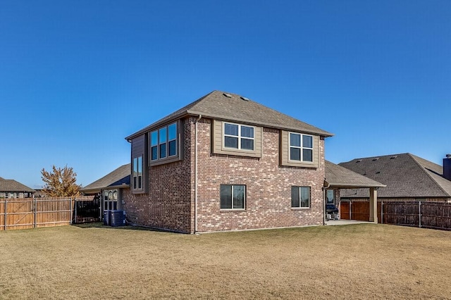 rear view of property featuring central AC and a lawn