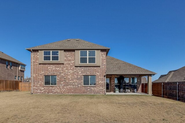 rear view of house with a patio area and a yard