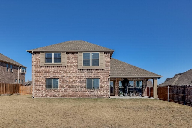 rear view of house with a patio and a yard