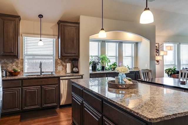 kitchen with dark brown cabinetry, sink, a center island, and dishwasher