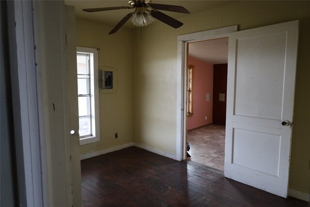 unfurnished room featuring dark hardwood / wood-style flooring, electric panel, and ceiling fan