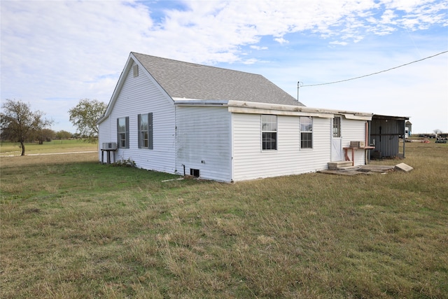 view of home's exterior with cooling unit and a lawn