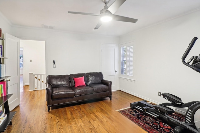 living room with crown molding, ceiling fan, and light hardwood / wood-style floors