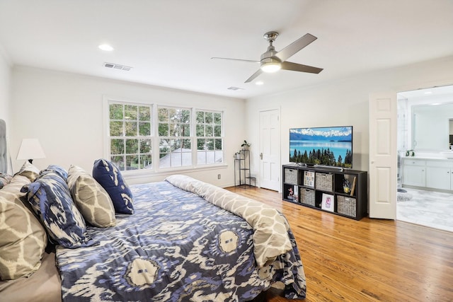 bedroom featuring wood-type flooring, ceiling fan, and ensuite bath