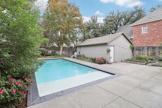 view of swimming pool featuring an outbuilding and a patio area