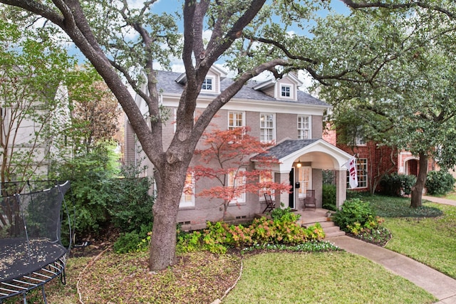 view of front of house with a trampoline and a front yard