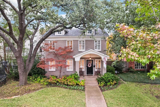 view of front of house featuring covered porch and a front yard