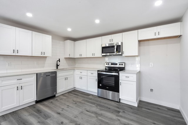 kitchen with sink, white cabinetry, stainless steel appliances, and dark wood-type flooring