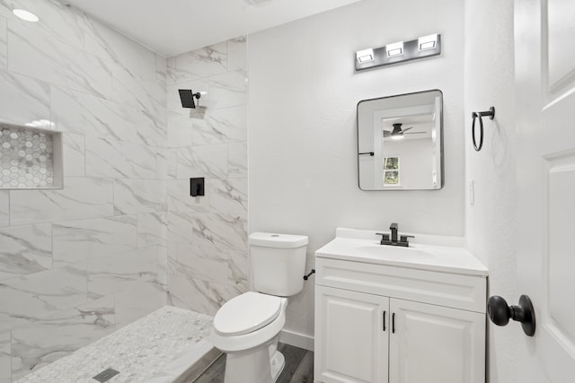 bathroom featuring hardwood / wood-style flooring, vanity, toilet, and a tile shower