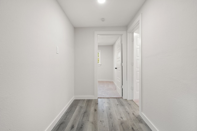 hallway with light hardwood / wood-style flooring