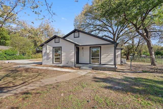 bungalow-style house featuring a porch, a front yard, and central AC