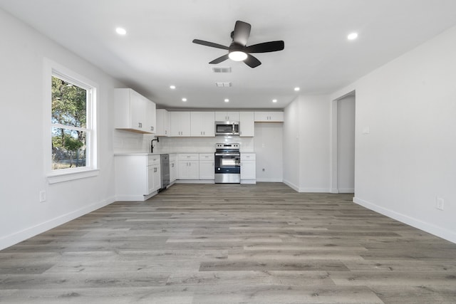 kitchen with ceiling fan, light wood-type flooring, white cabinetry, and appliances with stainless steel finishes