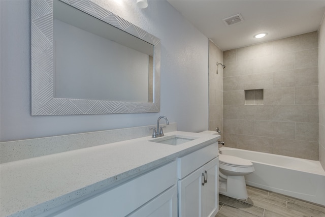 full bathroom with vanity, toilet, and tiled shower / bath