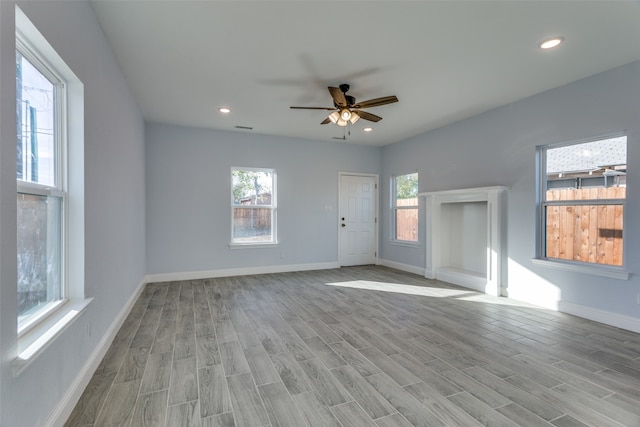 unfurnished living room with light wood-type flooring and ceiling fan