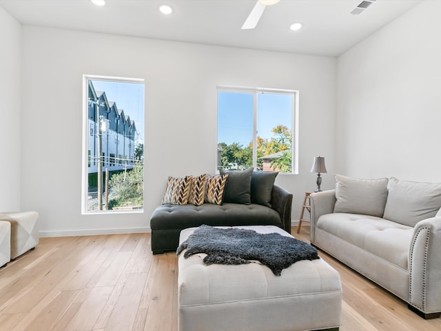 living room with light hardwood / wood-style floors and ceiling fan