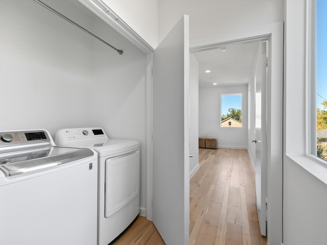 washroom with independent washer and dryer, light hardwood / wood-style floors, and plenty of natural light