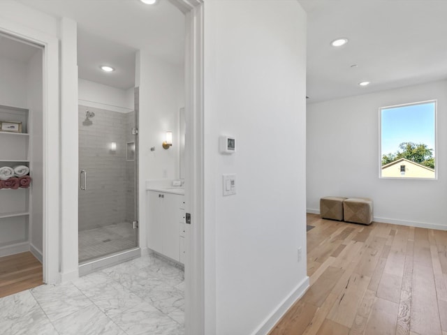 bathroom with an enclosed shower and hardwood / wood-style flooring