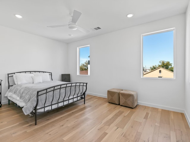 bedroom featuring light wood-type flooring, multiple windows, and ceiling fan