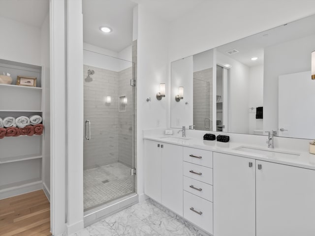 bathroom featuring hardwood / wood-style floors, vanity, and a shower with door