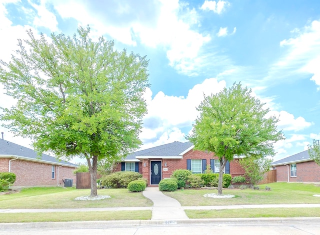 ranch-style home with a front lawn and central air condition unit