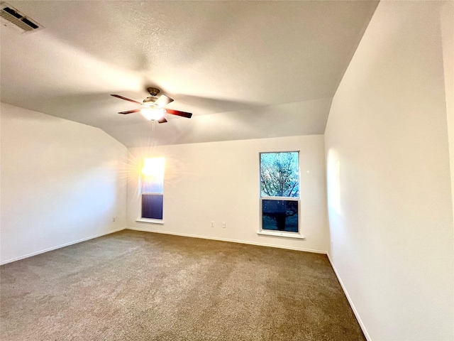 interior space with lofted ceiling, a textured ceiling, and ceiling fan