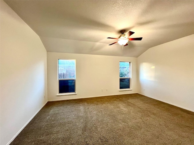 carpeted spare room with lofted ceiling, a textured ceiling, and ceiling fan