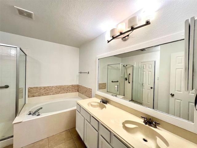 bathroom featuring tile patterned flooring, vanity, independent shower and bath, and a textured ceiling