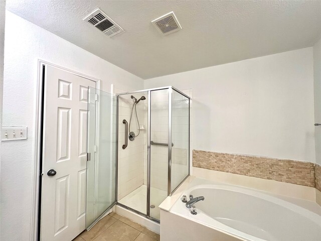 bathroom with tile patterned floors, plus walk in shower, and a textured ceiling