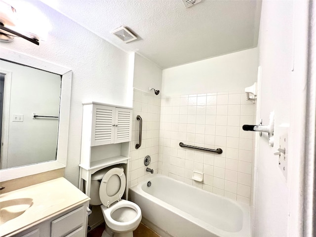 full bathroom featuring vanity, toilet, a textured ceiling, and tiled shower / bath