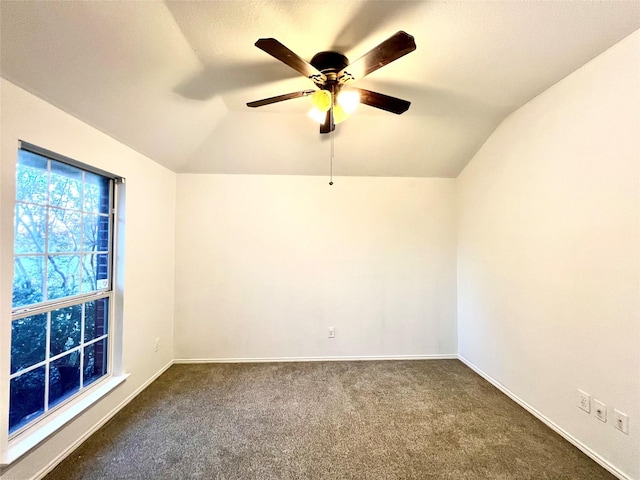 unfurnished room with ceiling fan, lofted ceiling, and dark carpet