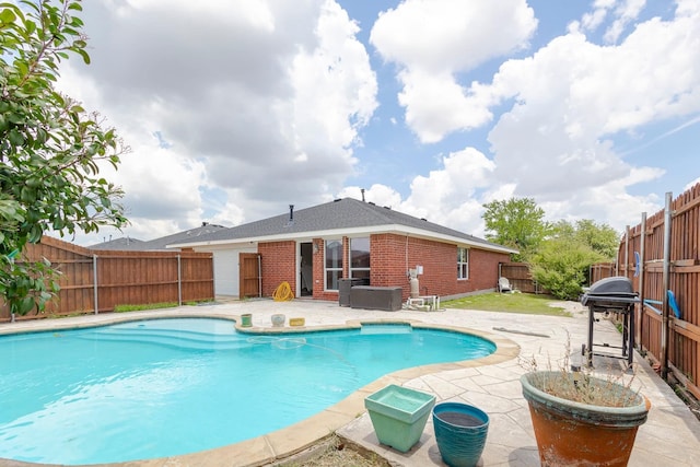 view of pool with grilling area and a patio area