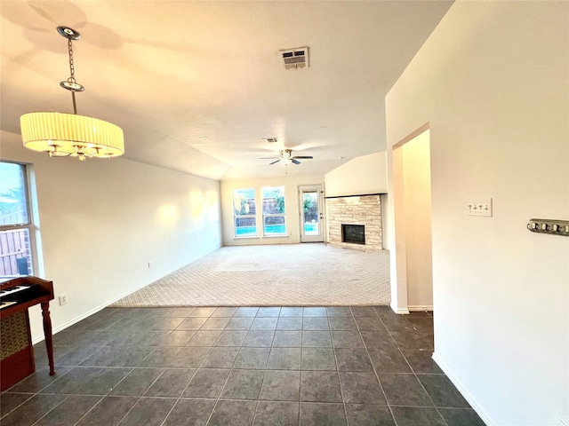 unfurnished living room with dark colored carpet, lofted ceiling, a fireplace, and ceiling fan