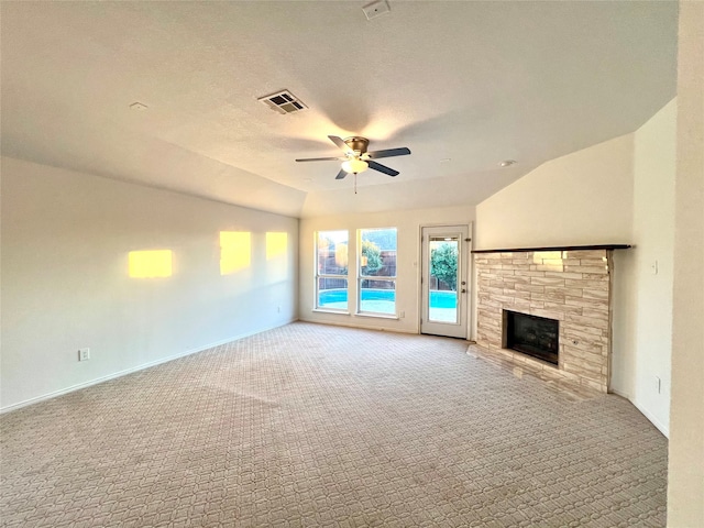 unfurnished living room featuring ceiling fan, light colored carpet, vaulted ceiling, and a textured ceiling