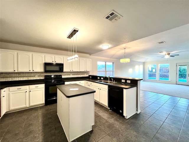 kitchen featuring sink, black appliances, a kitchen island, pendant lighting, and white cabinets