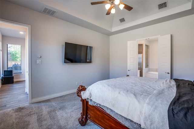 carpeted bedroom featuring ceiling fan, lofted ceiling, and ensuite bath