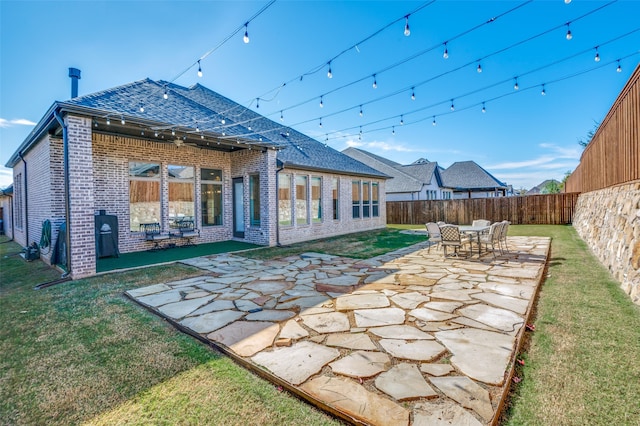 back of property with a lawn and a patio area