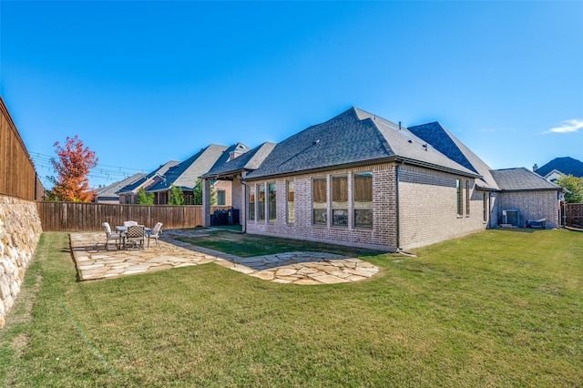 back of property with central AC, a patio area, and a lawn