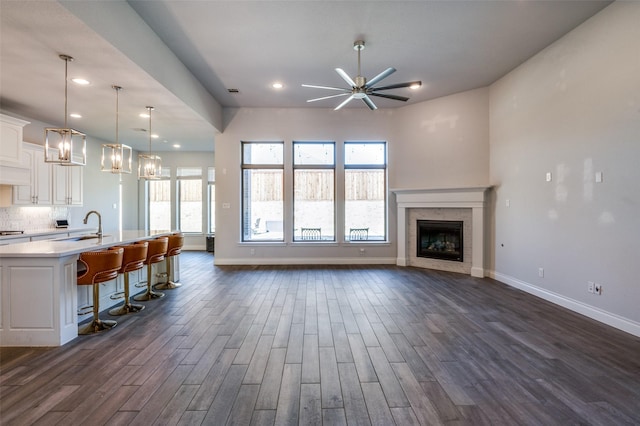 unfurnished living room with a fireplace, a healthy amount of sunlight, and dark hardwood / wood-style floors