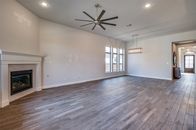 unfurnished living room with dark hardwood / wood-style floors, ceiling fan, and a wealth of natural light