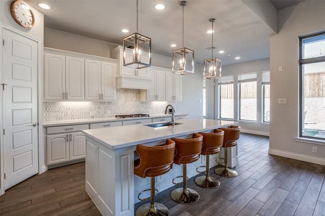 kitchen with white cabinets, a wealth of natural light, sink, and hanging light fixtures