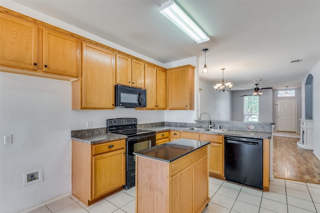 kitchen with sink, a center island, kitchen peninsula, black appliances, and ceiling fan with notable chandelier