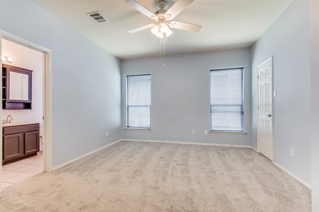 carpeted empty room with ceiling fan and sink