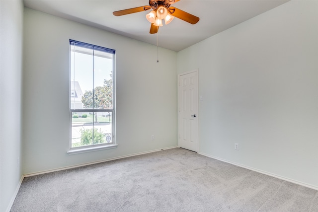 carpeted empty room featuring ceiling fan and plenty of natural light