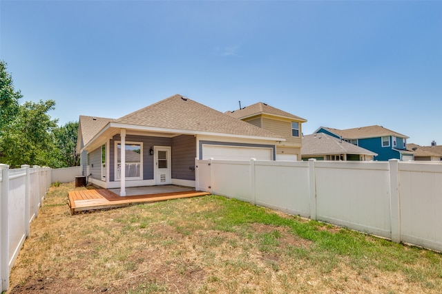 rear view of property with a yard and a deck