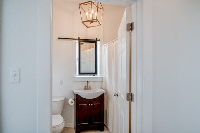 bathroom featuring vanity, toilet, and a chandelier