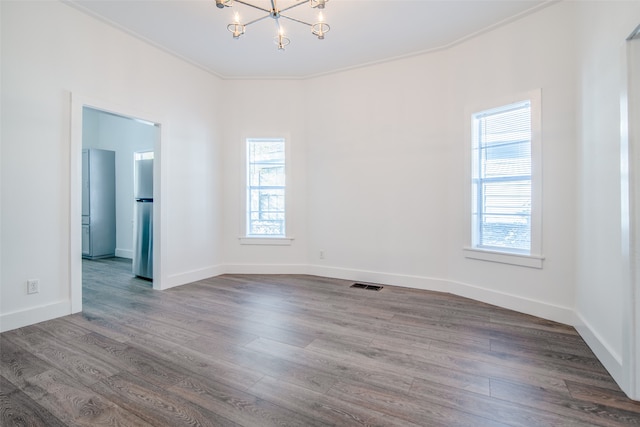 unfurnished room featuring a chandelier, hardwood / wood-style floors, and crown molding