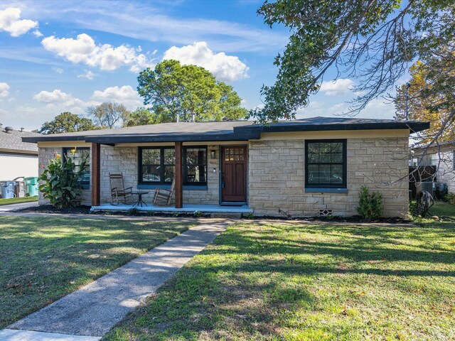 single story home with a front lawn and covered porch