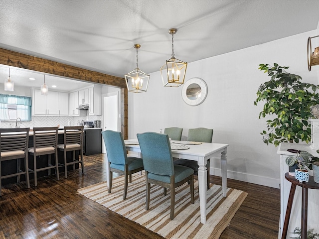 dining space featuring dark hardwood / wood-style flooring, sink, and a textured ceiling